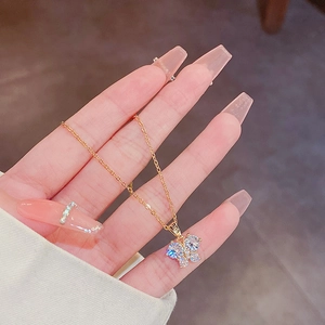Dettaglio di una collana con ciondolo a farfalla dorata e cristalli chiari brillanti