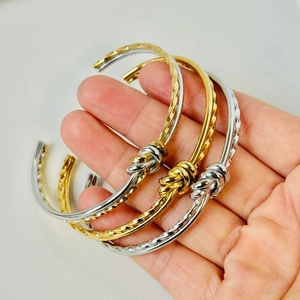 Detailed view of the twisted rope knot open bangle in gold and silver finish