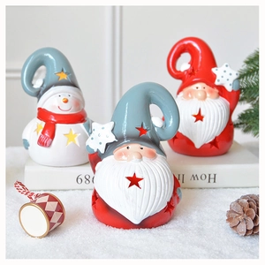 Cozy Christmas scene with hollow ceramic gnome and snowman statues on a snowy surface