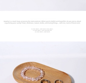 Detail view of pink beaded bracelet and silver rings on oval solid wood jewelry tray