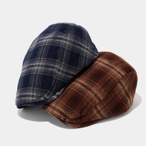 Detail of retro plaid newsboy caps in navy and brown showing texture and patterns
