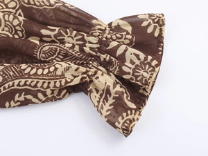 Detail van een bohemien paisley chiffon mouw met ruches aan de manchetten en patronen