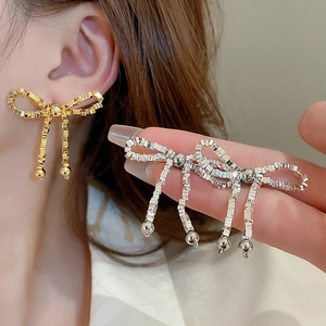 Collier élégant avec nœud métallique, perles argentées et longues chaînes à pompons