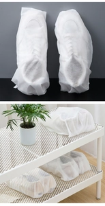 Non-woven white dust bags protecting shoes on a rack and a close-up of the fabric texture