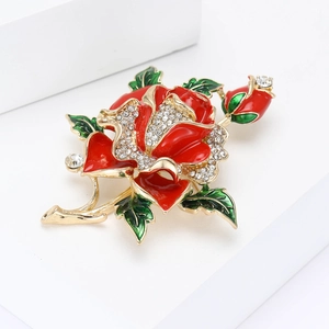 Elegant gold metal rose brooch with red enamel petals and sparkling crystal accents