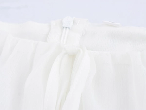 Detail of white dress back featuring an invisible zipper and delicate neck tie design