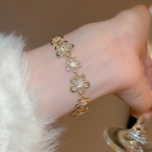 Elegant gold flower bracelet featuring hollow petals and sparkling cubic zirconia stones