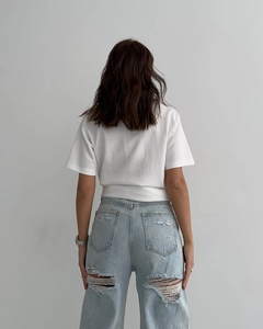 Vue arrière de jean bleu clair avec détails déchirés et t-shirt blanc en coton