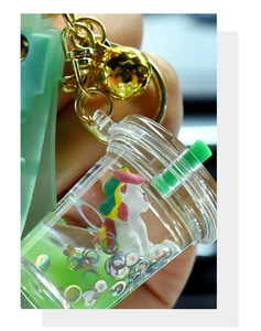 Detail of liquid unicorn keychain with green glitters and silicone wristlet strap