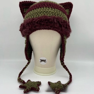 Detail of crochet cat ear hat with red and green stripes and star-shaped pendants