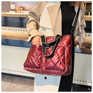 Close-up of metallic burgundy quilted handbag with striped strap and diamond pattern