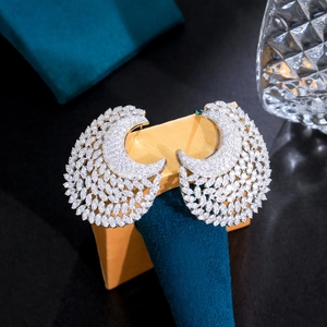 Macro shot of silver crescent earrings with sparkling pavé zircons on velvet stand