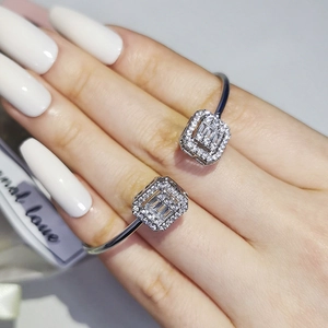Adjustable silver open bangle bracelet with rectangular geometric zircons on model