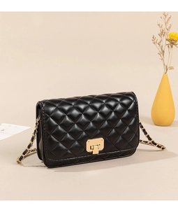 Detailed shot of black quilted faux leather crossbody bag with gold rectangular lock