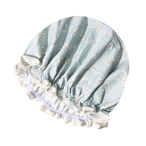 Detail of light blue floral shower cap featuring elastic band and decorative white frill edge