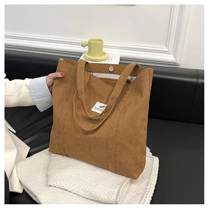 Detail of a brown corduroy tote bag showing high-capacity design and textured fabric