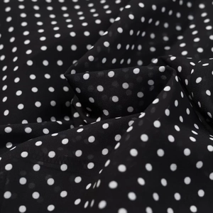 Nahaufnahme von weichem schwarz-weißem Polka-Dot-Stoff mit feiner Textur und Fall