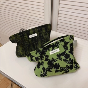 Close-up of retro green floral jacquard makeup bags with simple wish woven labels