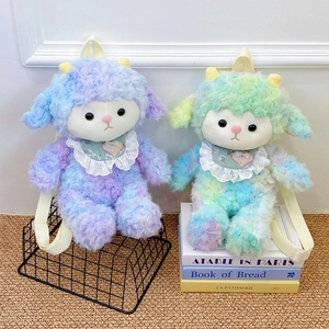 Plush lamb backpacks in purple and teal tie-dye curly fur with lace bibs on decorative books