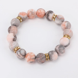 Detailed view of 8mm pink zebra jasper beads and golden rhinestone spacers on a beaded bracelet