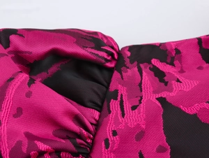 Macro shot of rose red and black jacquard fabric with detailed woven texture on dress