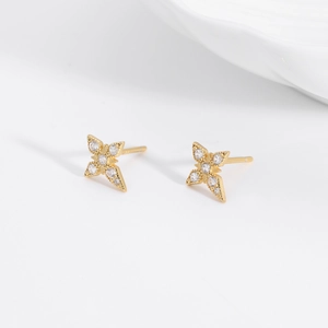 Macro detail of gold S925 sterling silver four-pointed star stud earrings with cubic zirconia