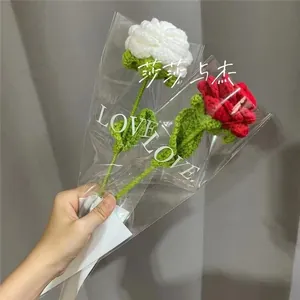 Close-up of handmade crochet flowers in red and white colors with Love text packaging