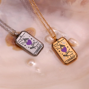 Detail of tarot card pendant necklace in gold and silver finish on a pearl base