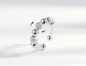 Detail of silver anxiety ring with rotating beads in matte and polished finishes