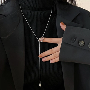 Silver chain pearl necklace shown on a model wearing a black turtleneck and blazer
