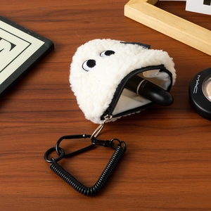 Macro shot of a white plush rice ball coin purse holding a lipstick on a wooden desk