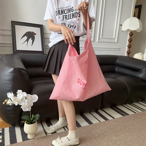 Detailed view of pink canvas tote bag with SUN lettering print for casual shopping use