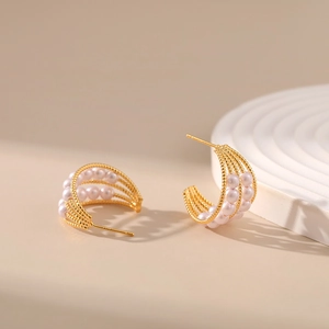 Dettaglio di orecchini a cerchio barocchi placcati oro 18K con spirali e perle eleganti
