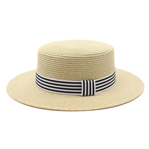 Detailed texture of beige straw weave flat top hat with black and white striped ribbon