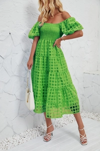 Close-up of lightweight green plaid fabric and detailed smocked bodice on summer dress