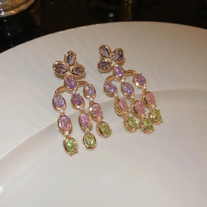 Detail of colorful faceted crystal heart earrings on a white ceramic display tray