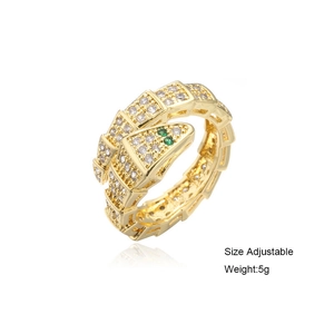 Detail view of gold snake ring with white zircon pave and green gemstone eyes