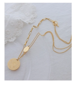 Detail of gold coin necklace featuring Queen portrait and dual texture chain links