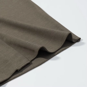 Macro shot of dark olive knitted fabric with detailed overlock stitching and soft texture