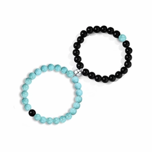 Close-up of magnetic heart clasp connecting black and blue natural stone bead bracelets