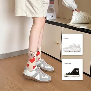 Cute cartoon bear and apple patterned mid-calf socks with grey sneakers on wooden floor