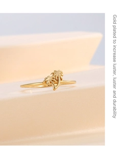 Detailed view of gold plated palm tree rings on a minimalist geometric display stand