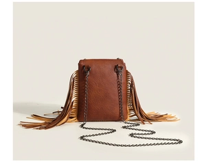 Detailed view of the brown leather mini bag with side fringes and black metal chain