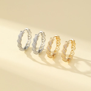 Detailed view of gold and silver twisted hoop earrings with micro-pave cubic zirconia stones