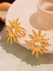 Artistic close-up of gold sunflower open rings on minimalist stone display stand