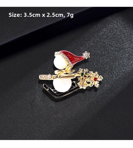 Detailed view of snowman brooch with red enamel hat and pearls on black background