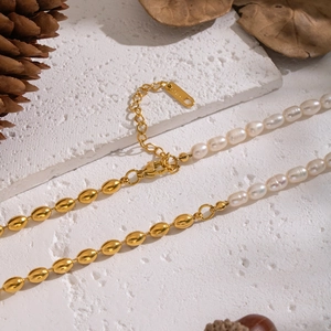 Detailed macro view of vintage gold stainless steel chain with natural freshwater pearls