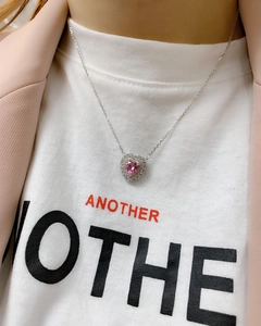 Close-up of heart-shaped pink carbon diamond pendant necklace on model with halo setting