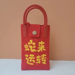 Close-up of red woven phone bag with yellow Chinese embroidery and silicone strap