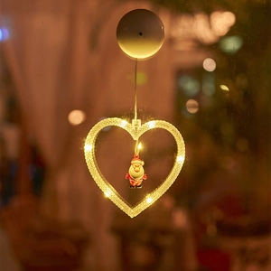Close-up of heart-shaped Christmas suction cup light with Santa Claus and warm LED glow